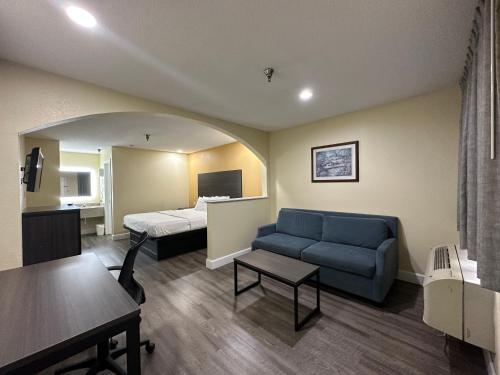 a living room with a couch and a bed in a room at Rodeway Inn and Suites Hwy 290 in Houston