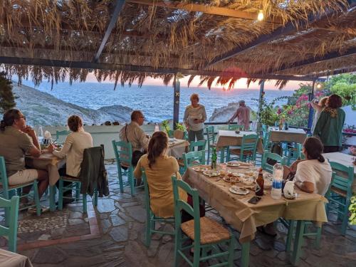 a group of people sitting at a restaurant on the beach at ARTEMIS STUDIO - NAS in Armenistis