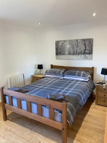 a bedroom with a bed with a blue comforter at The Chalet, 444 North Lochboisdale in Lochboisdale