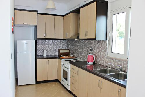 a kitchen with a white refrigerator and a sink at Sunny Apts in Sarandë