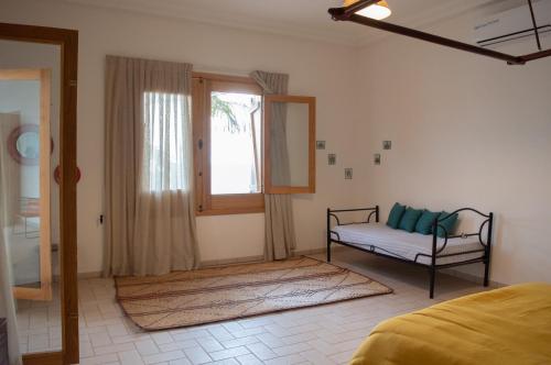 a bedroom with a bed and a window and a couch at Sur la Plage Yenne in Yenne-Todé