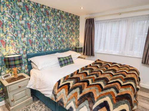 a bedroom with a bed with a colorful wallpaper at Helm Crag in Grasmere
