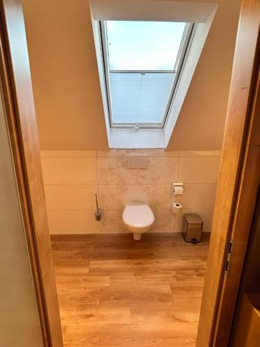 a bathroom with a toilet with a window at Laupus-Hof in Bad Vilbel
