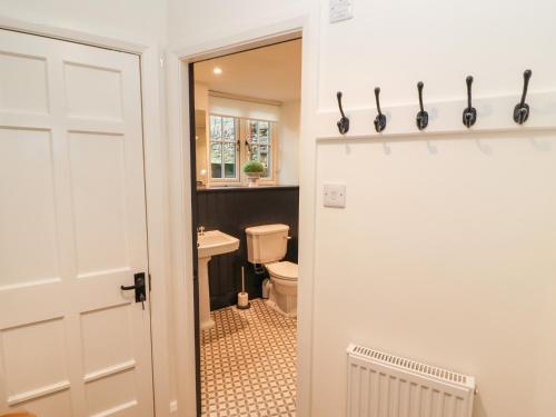 a bathroom with a toilet and a white door at Tilly's Cottage in Grasmere
