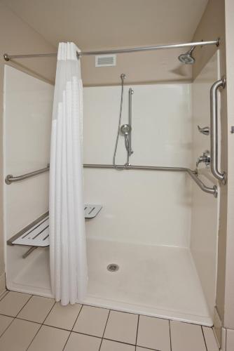 a shower with a white shower curtain in a bathroom at Holiday Inn Express and Suites St. Cloud by IHG in Saint Cloud
