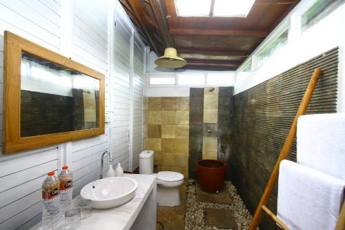 a small bathroom with a toilet and a sink at PASERANG PARIRI PARADISE in Labuberu