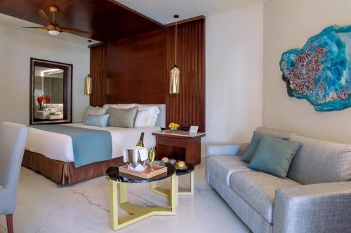 a hotel room with a bed and a couch at Secrets Royal Beach Punta Cana - Adults Only in Punta Cana