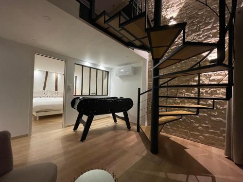 a staircase leading to a room with a piano and a bedroom at Duplex vieux marché quartier historique wifi/parking in Rouen