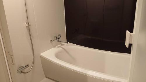 y baño con bañera blanca y espejo. en Mari Beauty Salon 2F - Vacation STAY 16557v en Sado