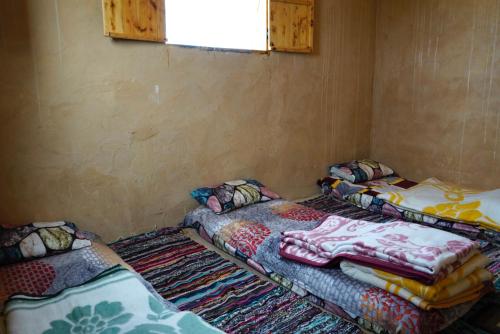 two beds sitting in a room with a window at Barahsiwa in Siwa