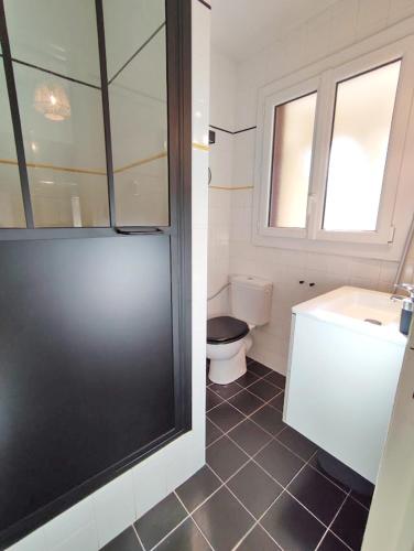 une salle de bain avec toilettes, lavabo et fenêtre dans l'établissement L'Escampette, Duplex T3, centre Luchon, wifi, casier à skis, 4 personnes, à Luchon