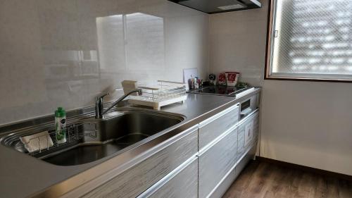 a kitchen with a stainless steel sink and a window at Annex Kanazawa - Vacation STAY 31114v in Kanazawa