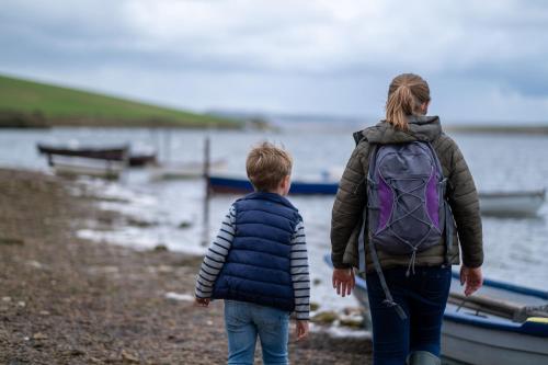 a boy and a girl with a backpack walking on the beach at Moonfleet Manor Hotel in Weymouth