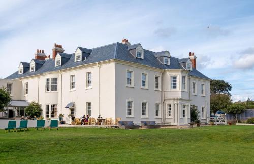 a large white house with a large yard at Moonfleet Manor - A Luxury Family Hotel in Weymouth