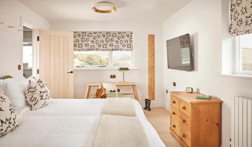 a bedroom with a bed and a window and a table at Moonfleet Manor Hotel in Weymouth