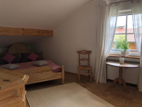 une chambre avec un lit, une table et une fenêtre dans l'établissement Ferienwohnung / Appartement Bergliebe, à Garmisch-Partenkirchen