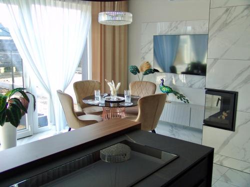 comedor con mesa, sillas y ventana en ZB Apartment Luxor Bobrowniki Rogożnik Pyrzowice, 