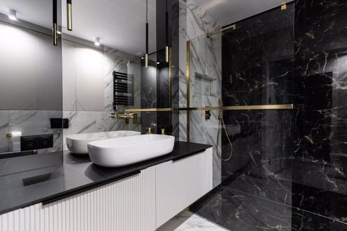a black and white bathroom with two sinks on a counter at ZB Apartment Luxor Bobrowniki Rogożnik Pyrzowice 
