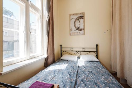 a bed in a room with a window at AirHome - Owl's Nest 2 in Tallinn