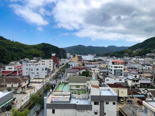 a city with buildings and mountains in the background at Hotel Tsushima - Vacation STAY 84601v in Tsushima