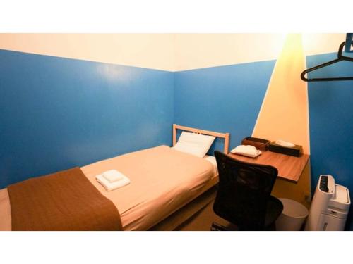a small room with a bed and a desk at fan! -ABURATSU- Sports Bar & HOSTEL - Vacation STAY 78451v in Nichinan