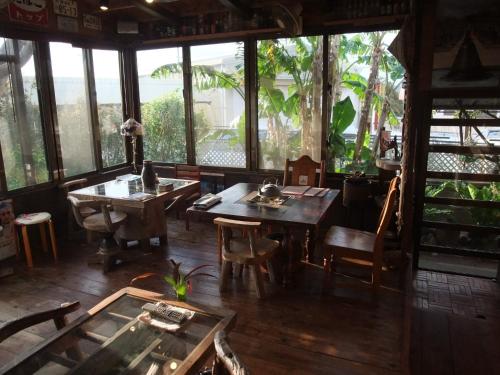 un comedor con mesas, sillas y ventanas en Minshuku Itoman Garigari Oshiro - Vacation STAY 25712v, en Itoman