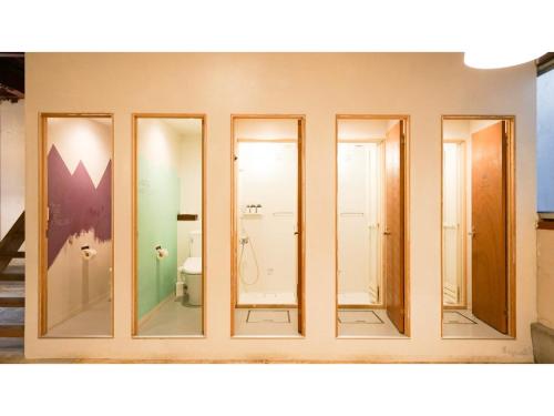 un bagno con quattro porte in vetro e un WC di fan! -ABURATSU- Sports Bar & HOSTEL - Vacation STAY 78433v a Nichinan