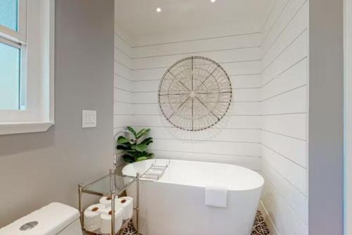 baño blanco con bañera y aseo en Wine Country Creekside Retreat With Hot Tub, en Glen Ellen