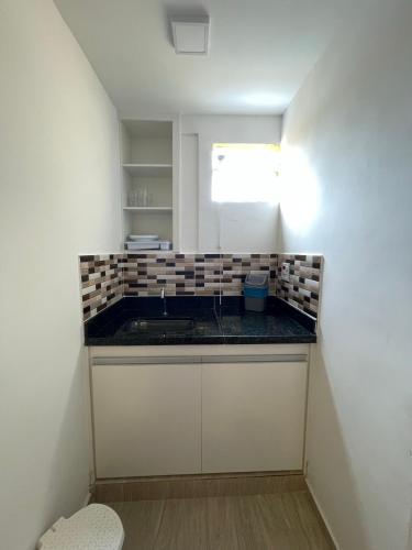 a small kitchen with a counter and a sink at Pousada Areias do Pero in Cabo Frio