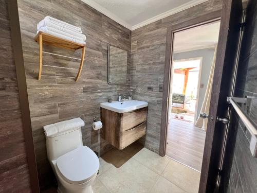 a bathroom with a toilet and a sink at Inaki Uhi Hotel in Hanga Roa