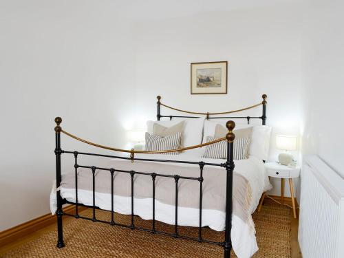 a bedroom with a black bed with white pillows at Harbour View in Johnshaven