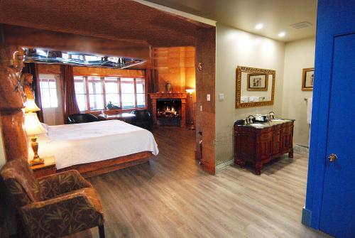 a bedroom with a large bed and a fireplace at Auberge Aux Nuits de Rêve in Sainte-Agathe-des-Monts