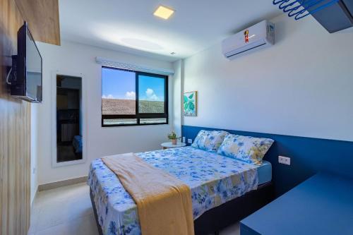 a small bedroom with a bed and a window at Porto Blue #303 - Apartamento por Carpediem in Porto De Galinhas