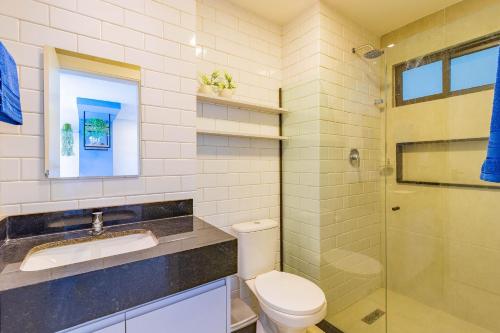 a bathroom with a toilet and a sink and a shower at Porto Blue #303 - Apartamento por Carpediem in Porto De Galinhas