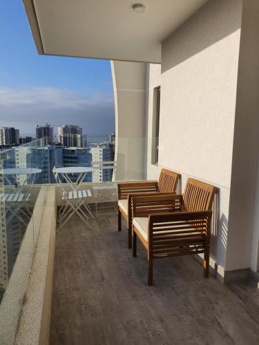 a balcony with chairs and a view of a city at Hermoso depto en Costa de Montemar, Vista al mar in Concón