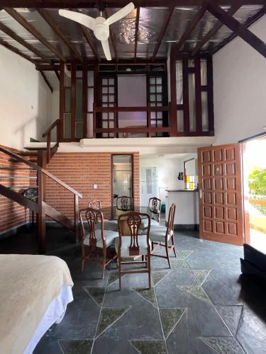 a room with a table and chairs and a kitchen at Pousada Areias do Pero in Cabo Frio