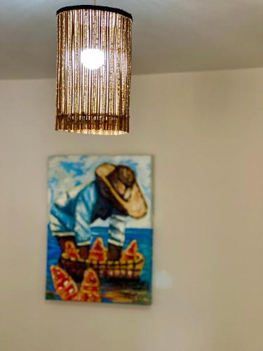 a painting hanging on a wall with a chandelier at Pousada Areias do Pero in Cabo Frio