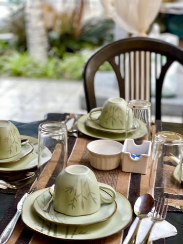 a wooden table with plates and hats on it at Pousada Areias do Pero in Cabo Frio