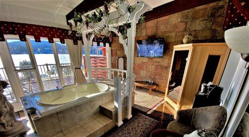 a bathroom with a tub in a room with windows at Auberge Aux Nuits de Rêve in Sainte-Agathe-des-Monts
