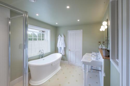 a bathroom with a white tub and a sink at The Ickworth Hotel And Apartments - A Luxury Family Hotel in Bury Saint Edmunds
