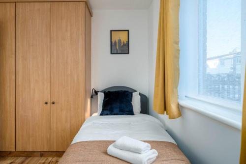 una piccola camera da letto con un letto con due asciugamani di 2 bedroom flat near London ExCel a Londra