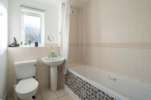 a bathroom with a toilet and a sink and a bath tub at 2 bedroom flat near London ExCel in London