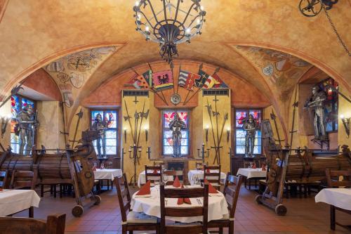 a restaurant with tables and chairs and stained glass windows at Pytloun Old Armoury Hotel Prague, Stará Zbrojnice in Prague