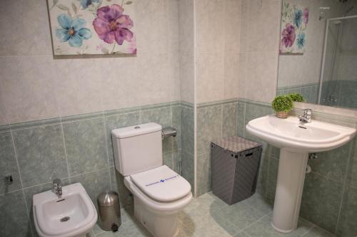 a bathroom with a toilet and a sink at AP Plaza la Hispanidad in Cuenca