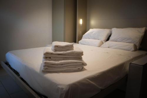 a stack of towels sitting on top of a bed at Il grifo in Licata