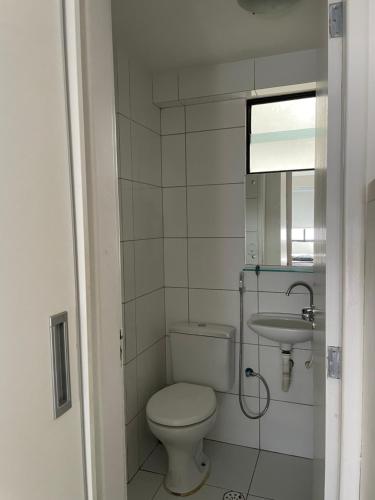 Baño pequeño con aseo y lavamanos en Apartamento Pajuçara, en Maceió