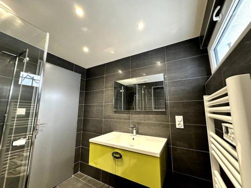 La salle de bains est pourvue d'un lavabo jaune et d'une douche. dans l'établissement APT. PRIVÉ «Le skieur» / Accès Ski / Cosy & équipé, à Gérardmer