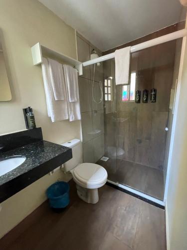 a bathroom with a shower and a toilet and a sink at Pousada Areias do Pero in Cabo Frio