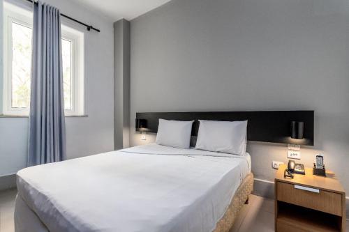 a bedroom with a large white bed and a window at Hotel Monte Castelo in Rio de Janeiro