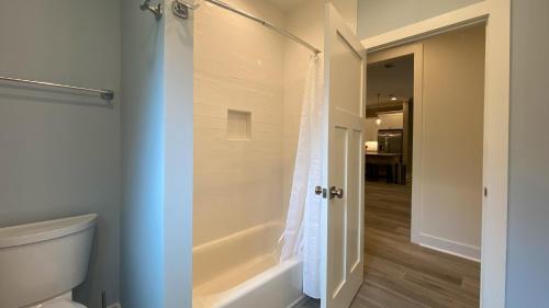 a bathroom with a tub and a toilet and a shower at SAND DOLLAR LODGE home in Jekyll Island